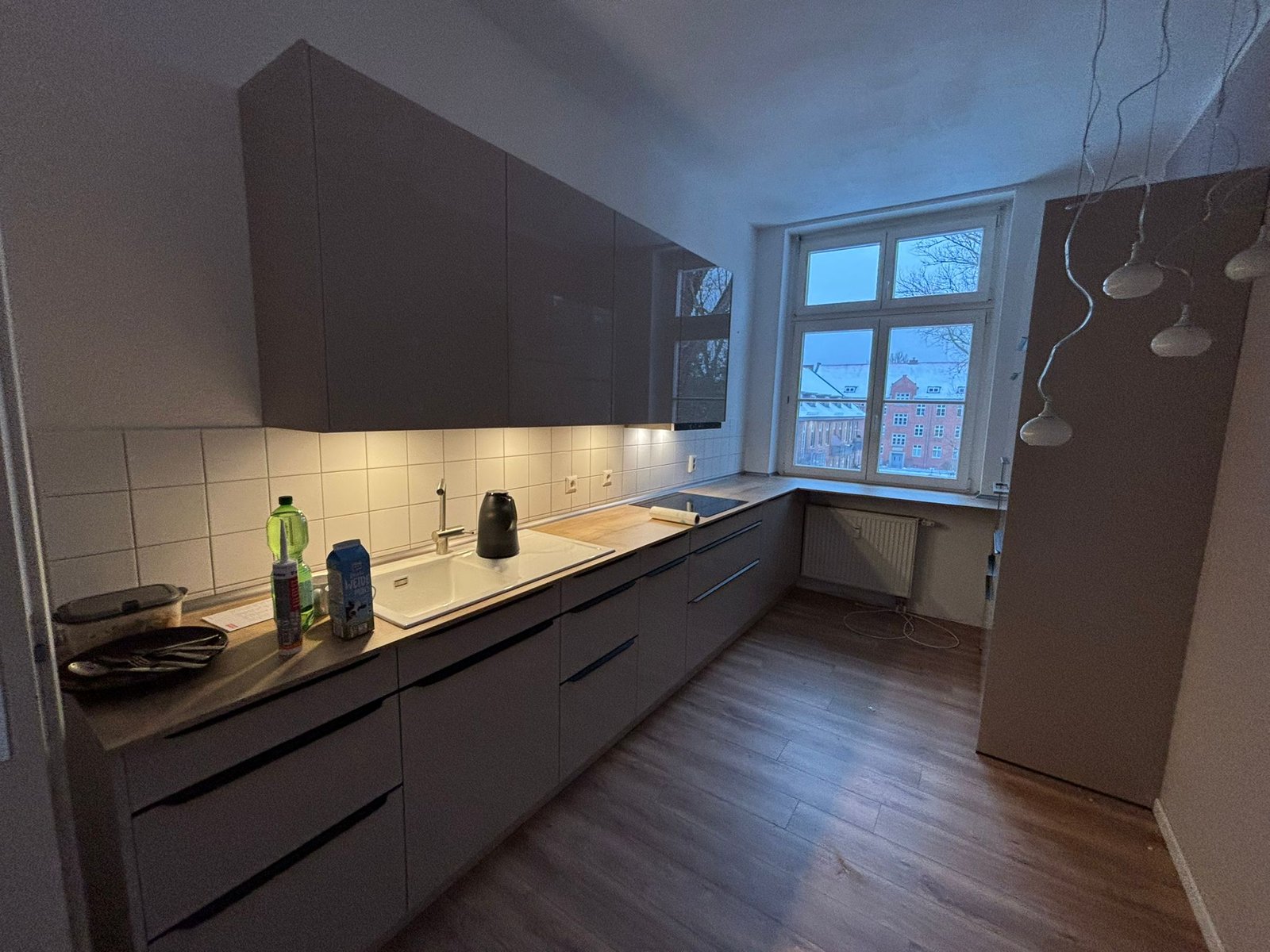Grifflose graue Küche mit Holzarbeitsplatte im Altbau
